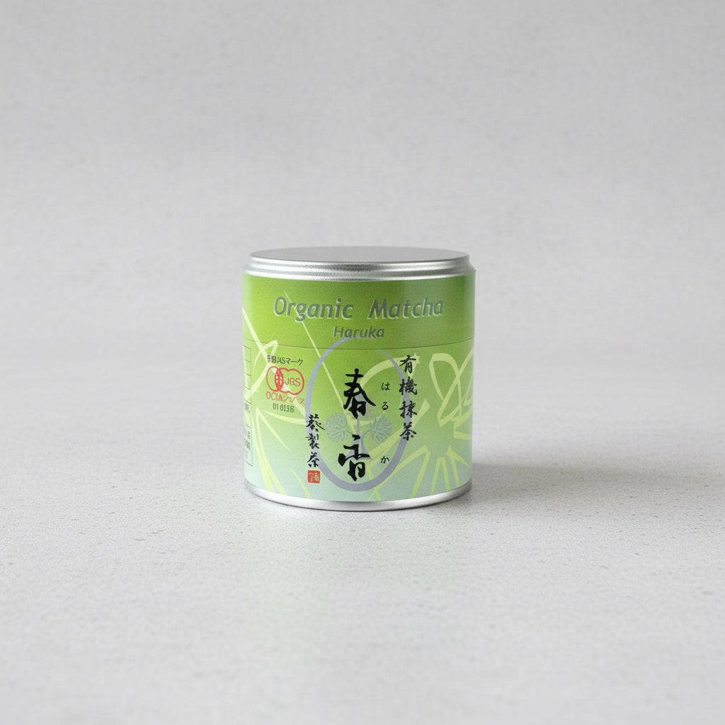 A green cylindrical can labeled 'Organic Matcha Haruka' on a wooden surface.