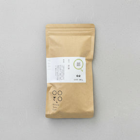 A packaged bag of Tomizawa Tea Garden's Kumamoto Shira-ore Leaf Stem Tea with a label indicating it's a naturally grown green tea product.